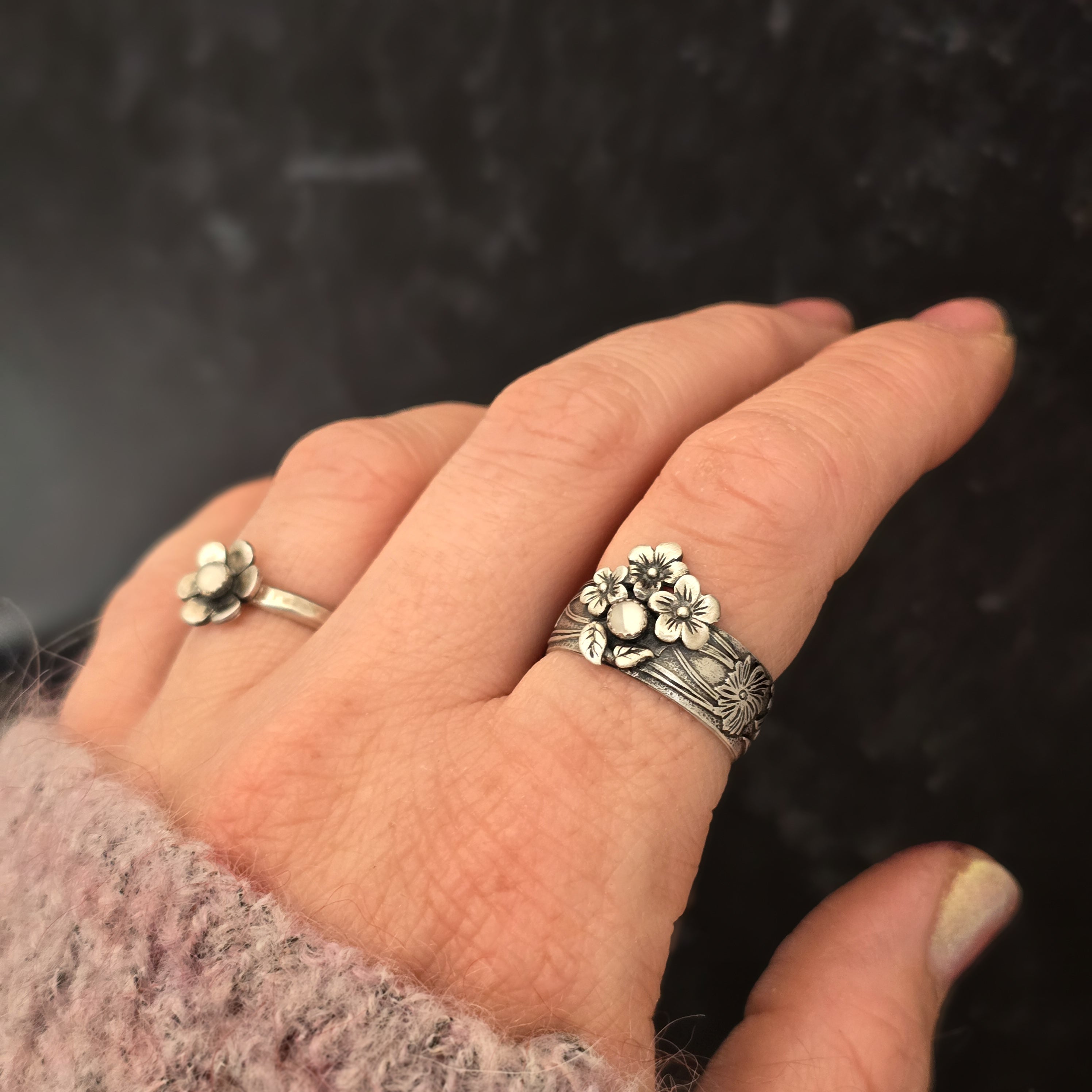 Handmade sterling silver floral band ring with moonstone worn on hand