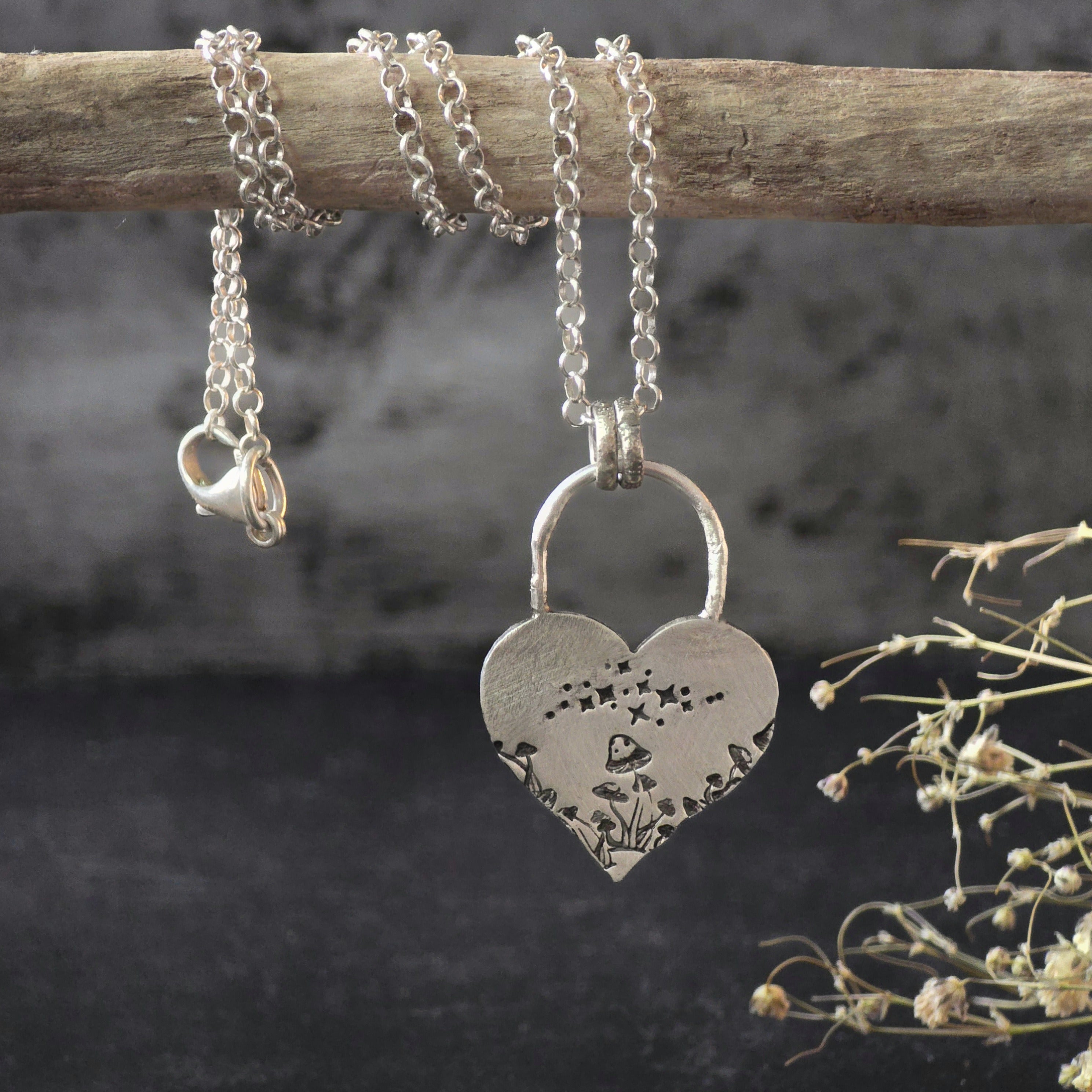 Sterling silver mushroom heart necklace hanging from branch