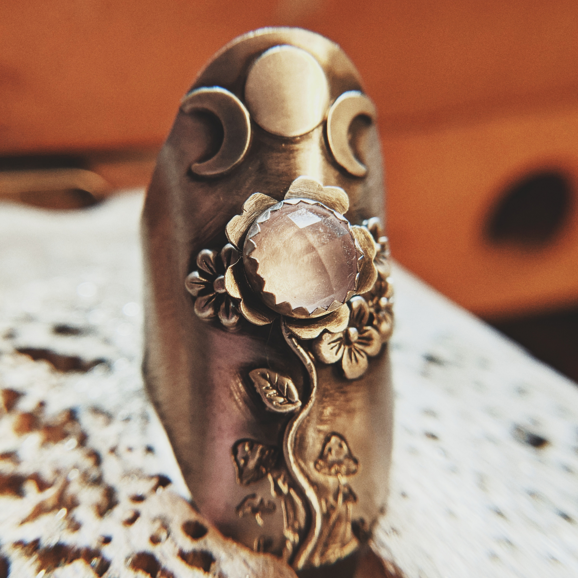 Triple Moon Goddess symbol on a ring with rose quartz stone and flowers and mushrooms