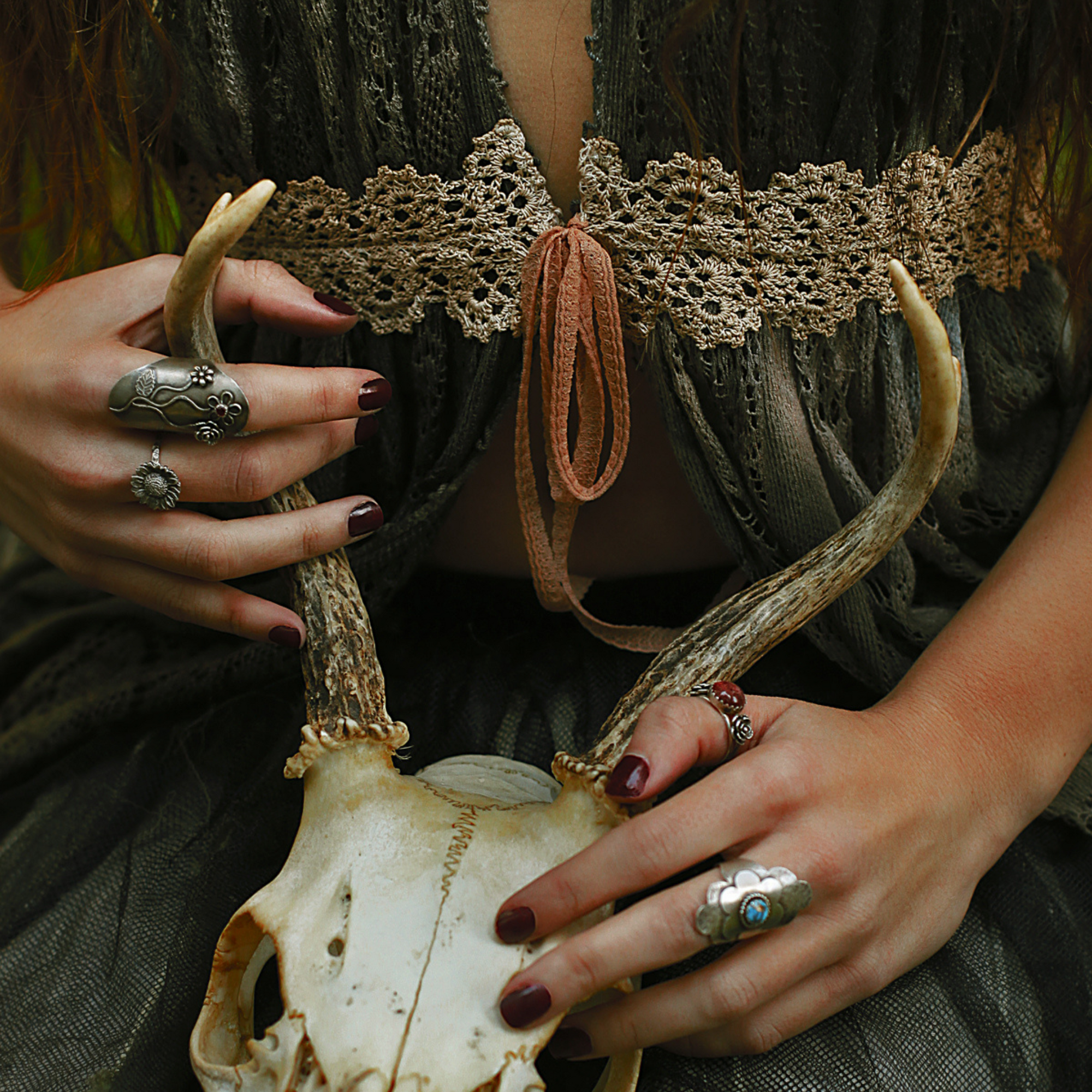 Witchy scene holding a skull with rings 