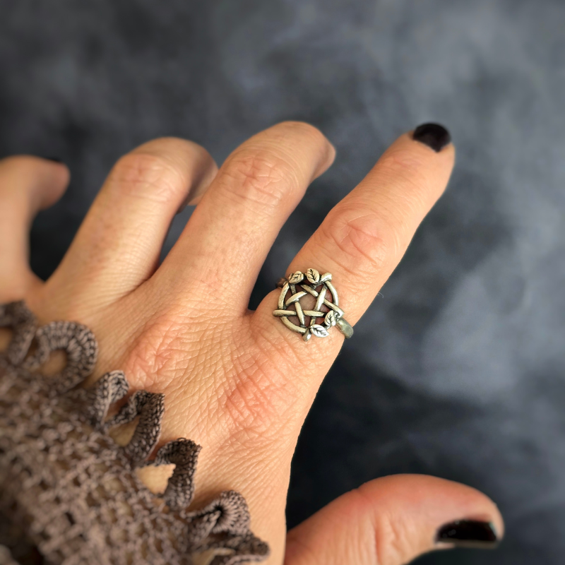 Hand wearing a Sterling Silver Pentacle Ring with Leaves with a dark background