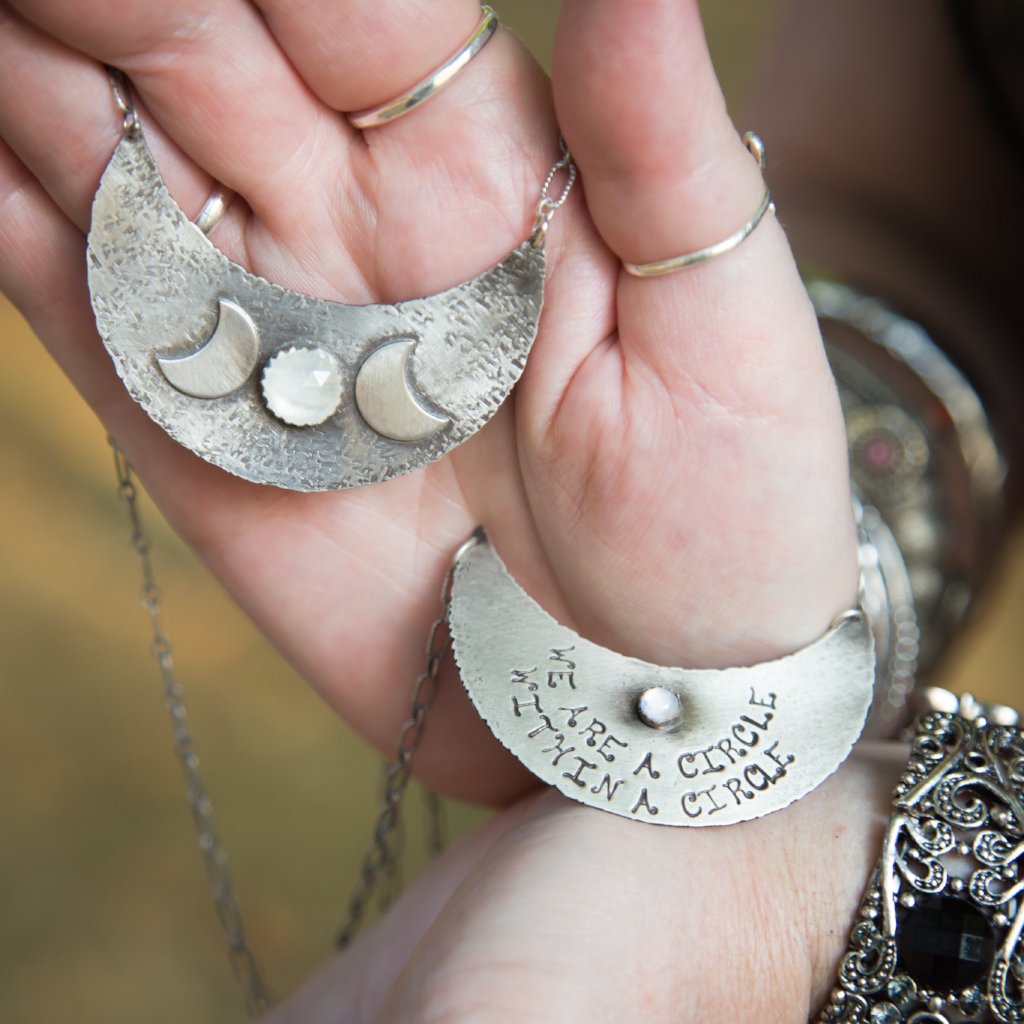 Triple Moon Goddess Necklace with Moonstone in hands of a model holding both of the necklaces showing each side of the pendant 