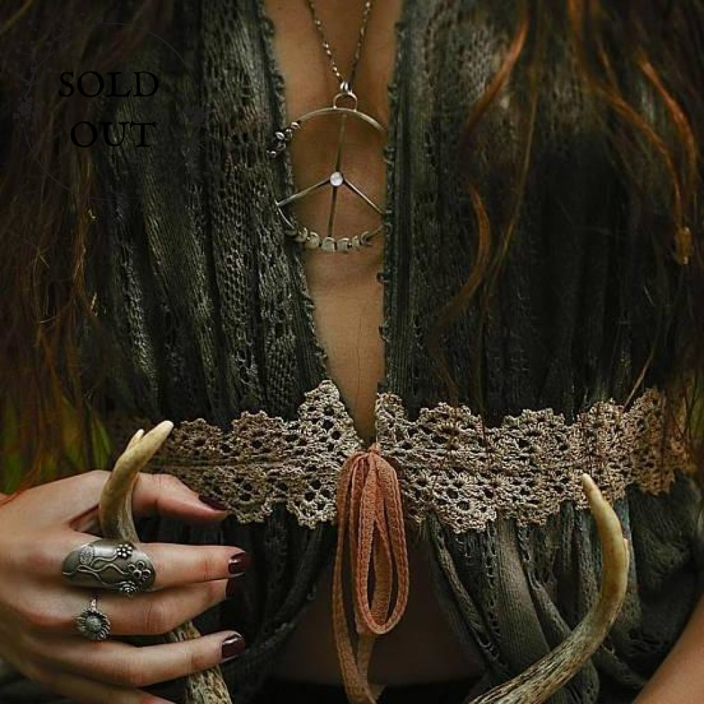 Moon Phases Peace Necklace with Moonstone  stylized photo on a model wearing the necklace and she holds a goat skull in the photo