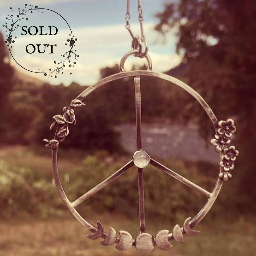 Moon Phases Peace Necklace with Moonstone close up 70s style photo with green background