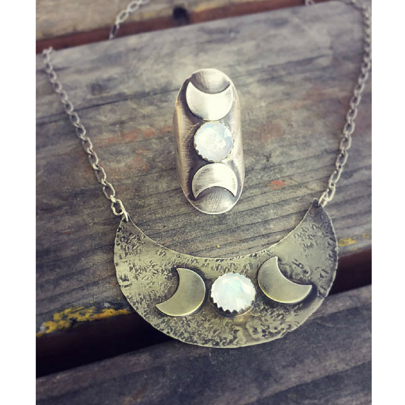 Triple Moon Goddess Ring with a Moonstone Moon phases photographed on a flat surface with matching necklace