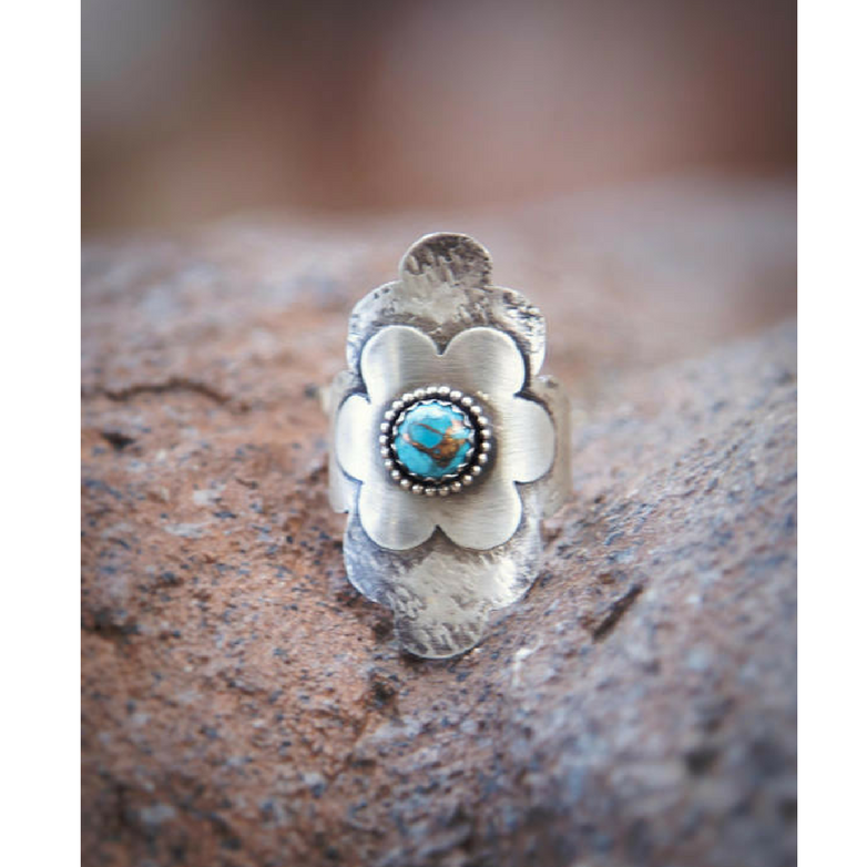 Turquoise Flower Statement Ring front view sitting between rocks 